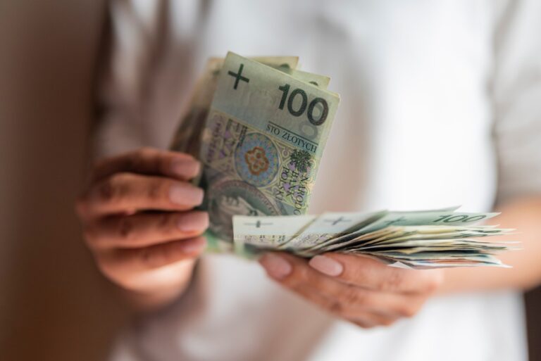 hands holding hundred zloty bills indoors 2026 03 15 23 30 10 utc Duze