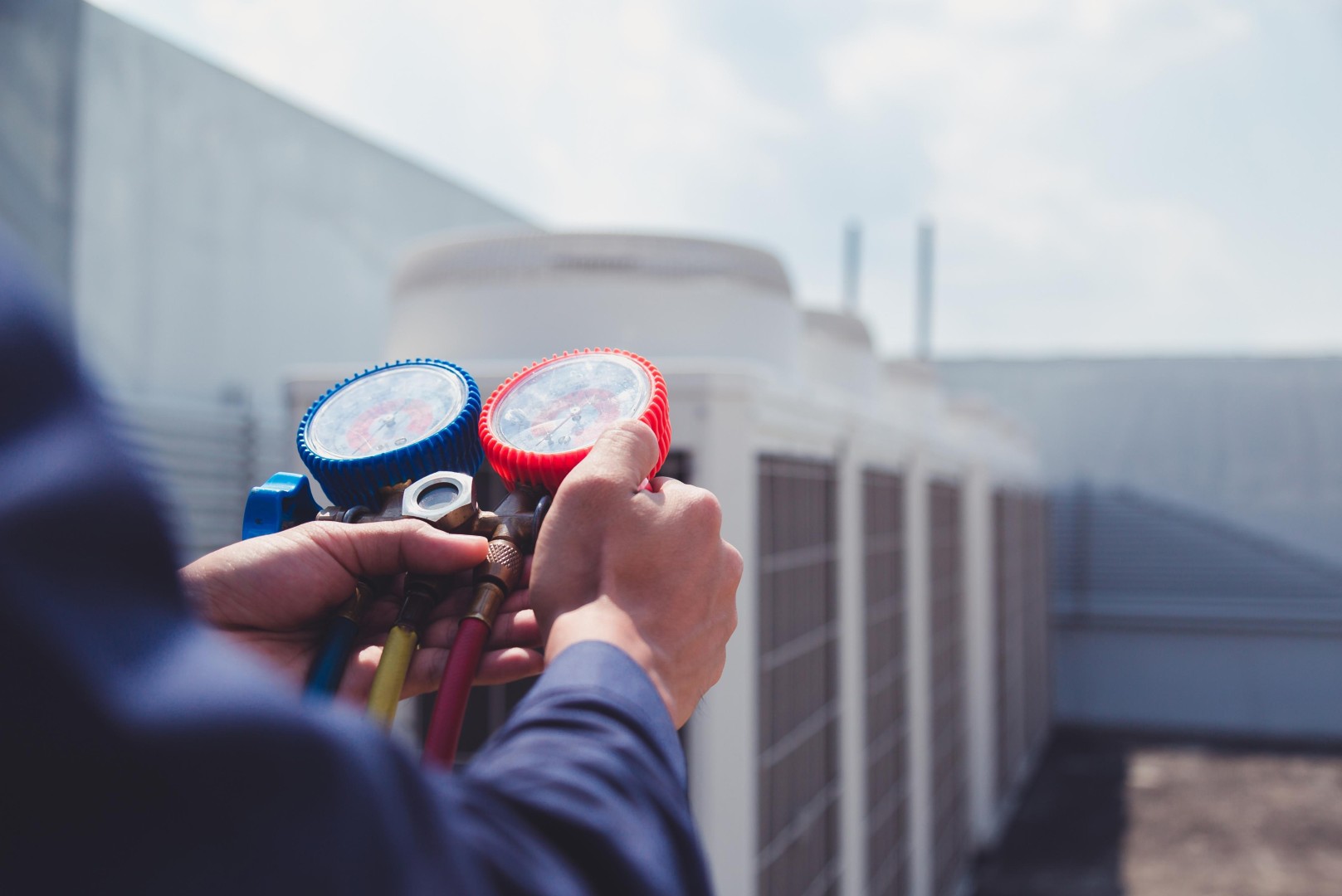 Technik HVAC sprawdzający ciśnienie czynnika chłodniczego w klimatyzacji za pomocą manometrów