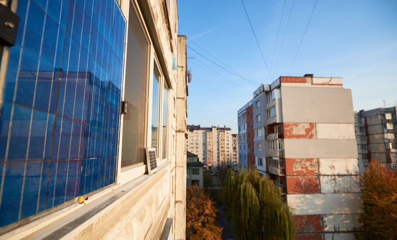 Panel fotowoltaiczny typu plug-in przymocowany do parapetu okna w mieszkaniu w bloku